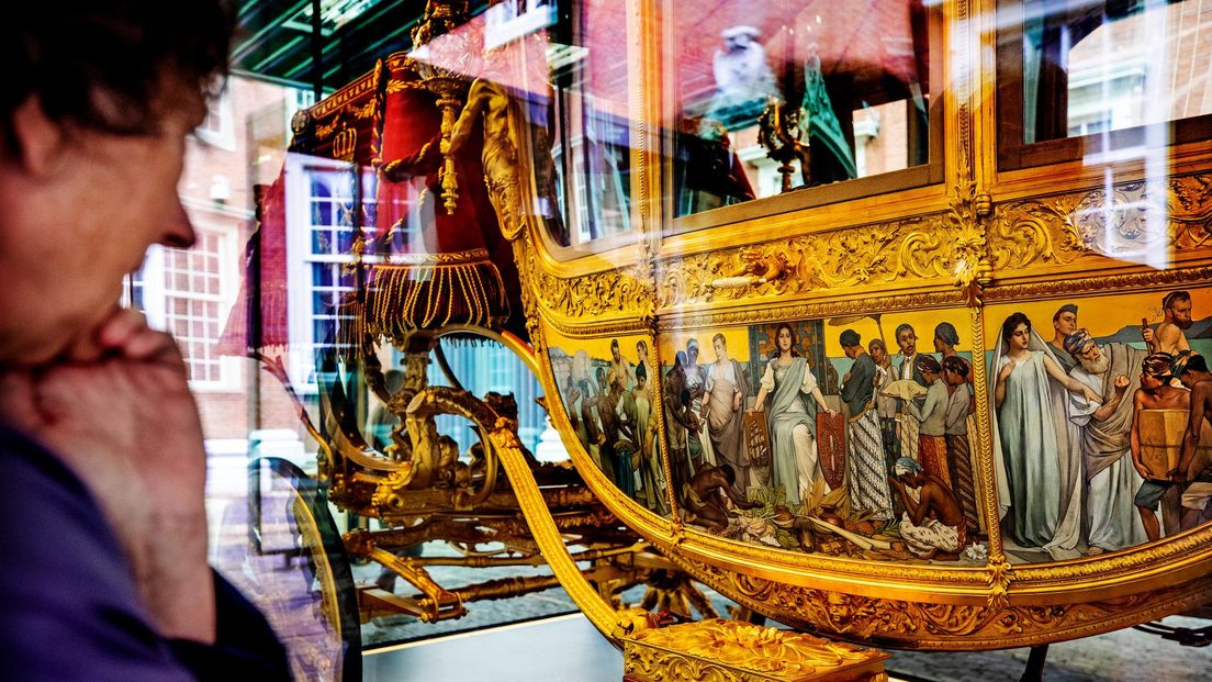Een bezoeker van het Amsterdams Historisch Museum bekijkt de beruchte panelen over het slavernij op de Gouden Koets.