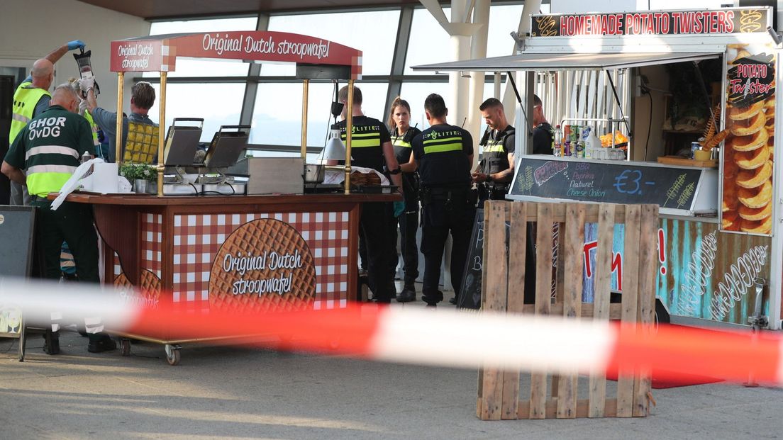 Hulpdiensten zijn bij de ingang van de Pier druk bezig met het slachtoffer