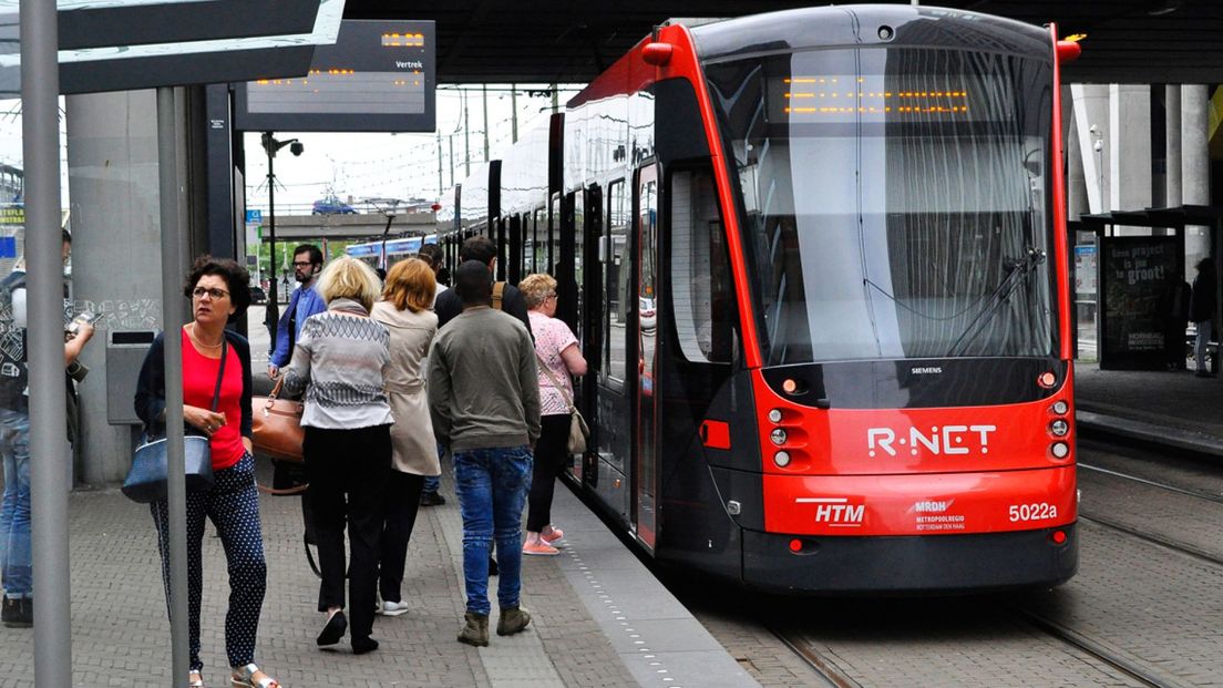 Passagiers stappen in een tram bij Den Haag Centraal
