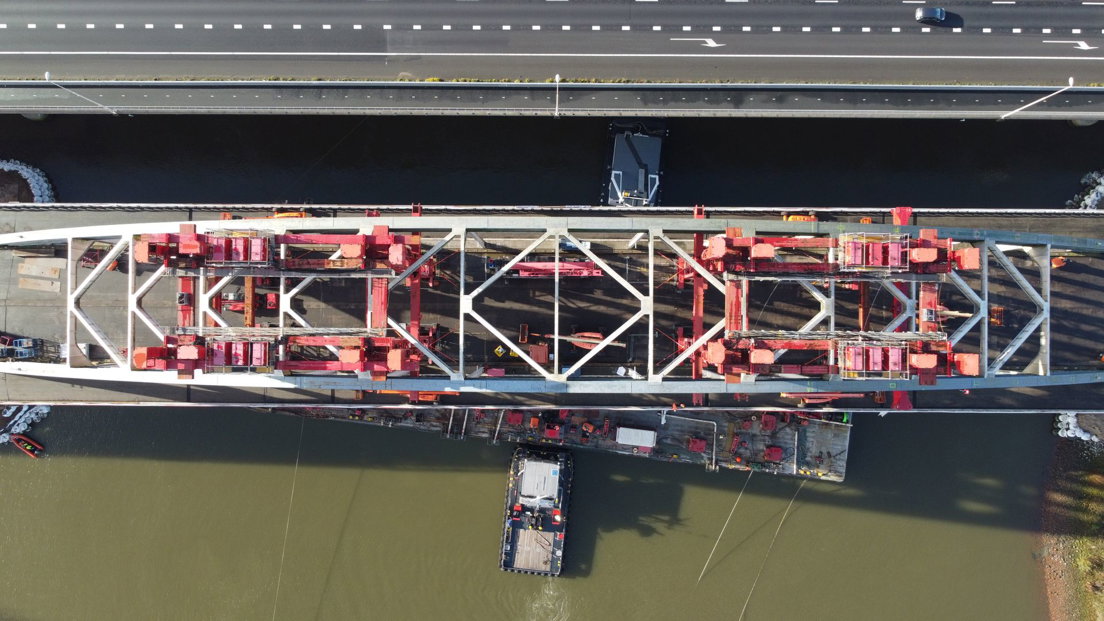 Als een vogel: van boven bekeken zie je dat 100 mensen hard aan het werk zijn om de brug te verwijderen.