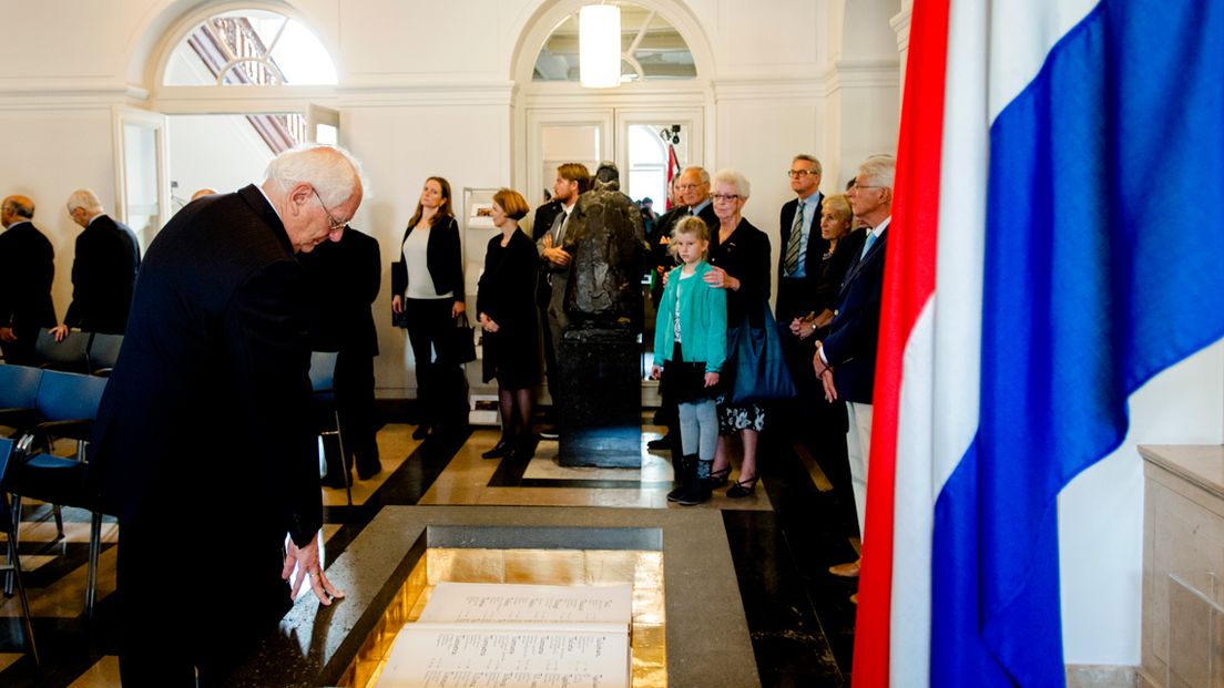 Een man betuigt zijn respect bij de Erelijst der Gevallenen’, het boek met de namen van Nederlandse militairen en verzetsstrijders die in de Tweede Wereldoorlog zijn omgekomen.
