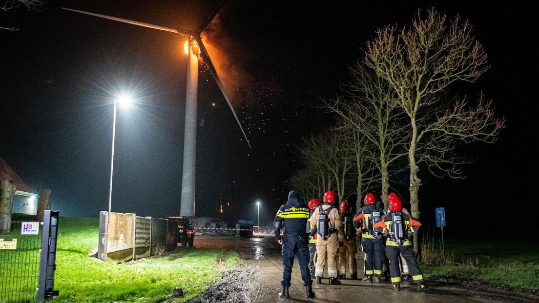 Hulpverleners aanschouwen de brand in de windturbine