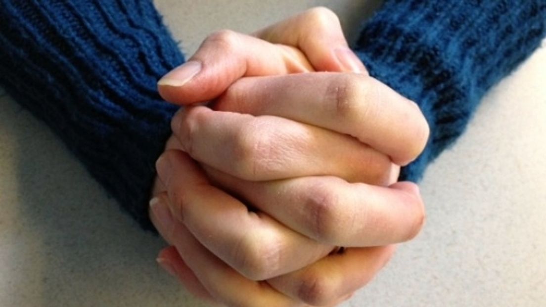 Handen gevouwen in gebed