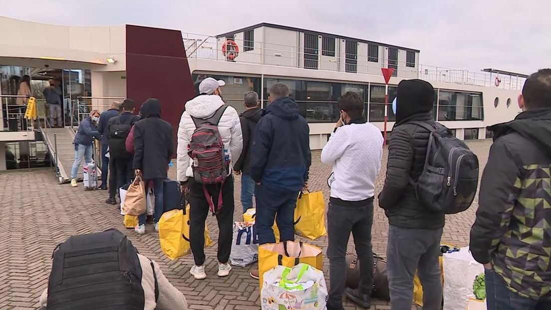 Vluchtelingen in de rij om het Arnhemse cruiseschip op te gaan.