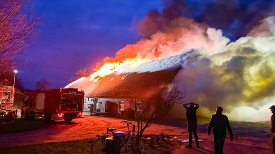 Vlammen slaan uit rieten dak van boerderij